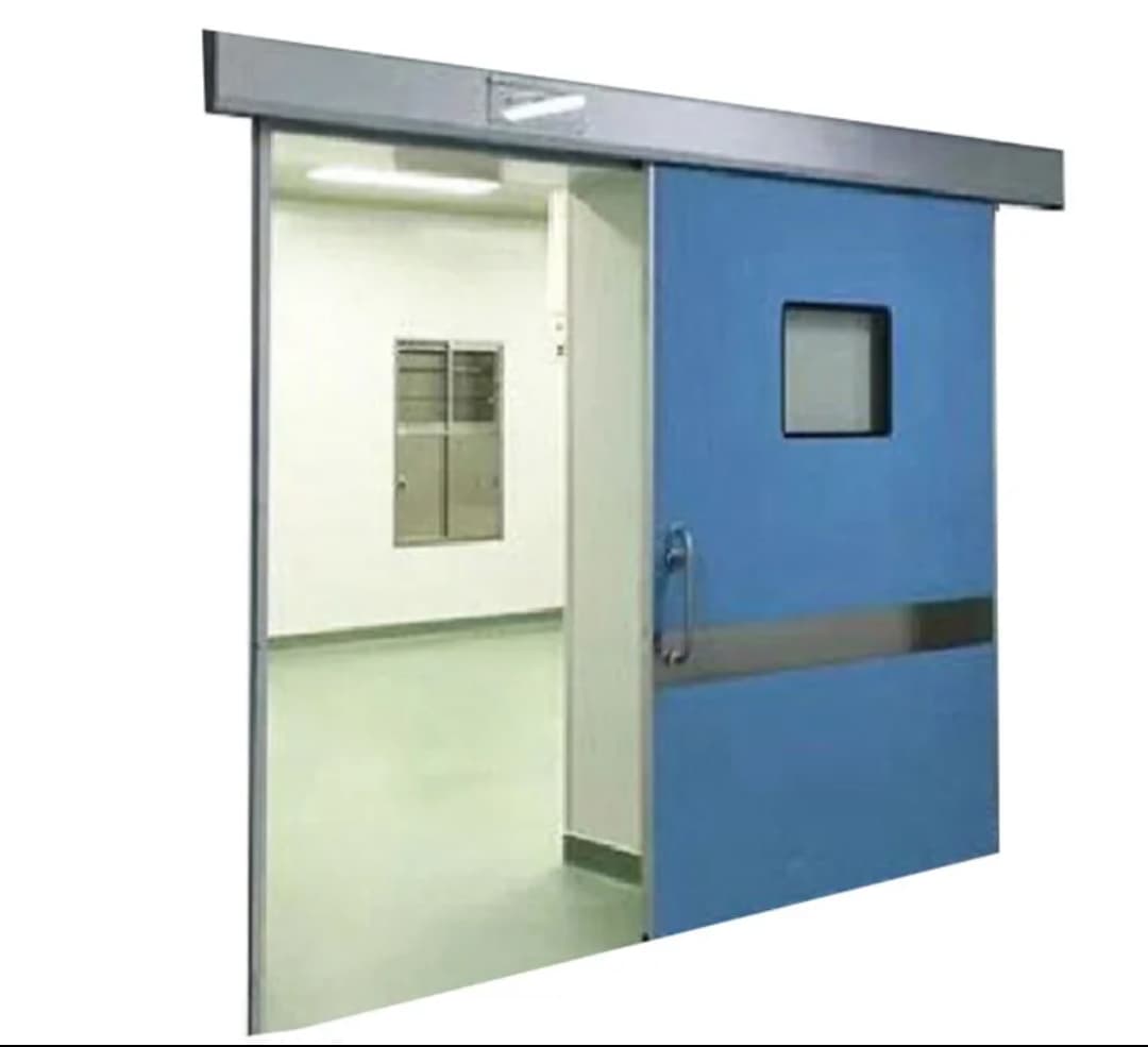Porte coulissante bleue avec petite fenêtre carrée ouverte sur une salle blanche au sol vert.